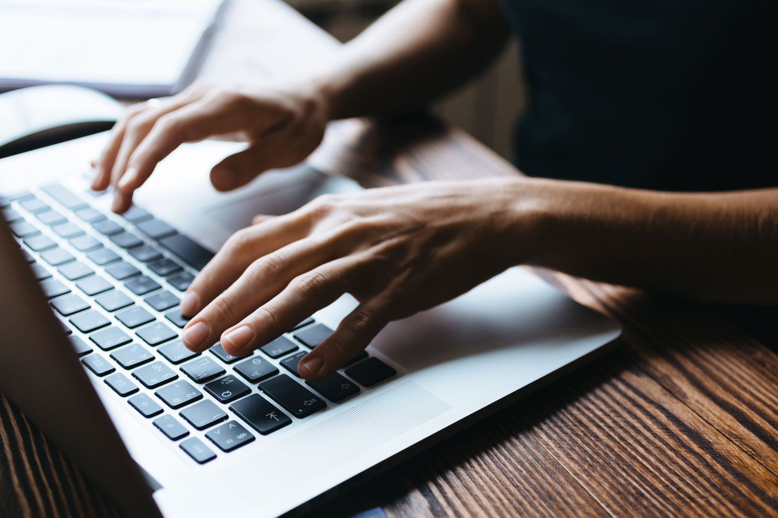Hands typing an email campaign on a laptop