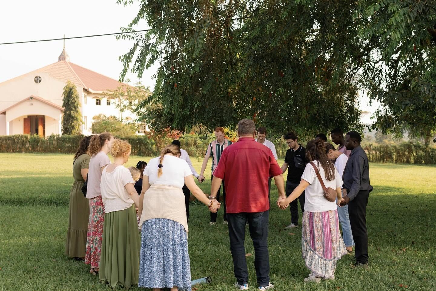 A prayer circle on the lawn outside a church with The Gospel Church family