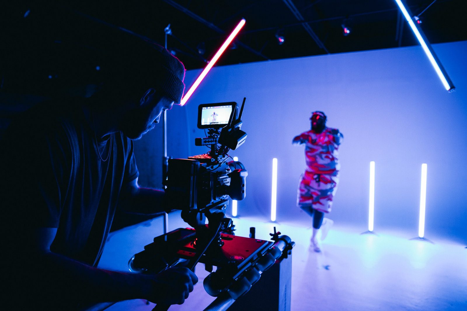 A camera operator filming a dancer on a lit studio set